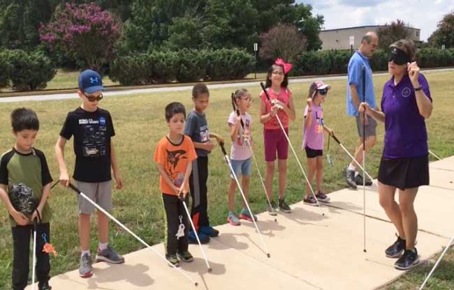 shows BELL students with their white canes outside on a sidewalk.