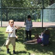 shows children at play in the grass.
