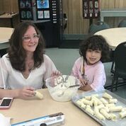 shows a volunteer and NFB BELL student with a bowl and a tray of bananas.