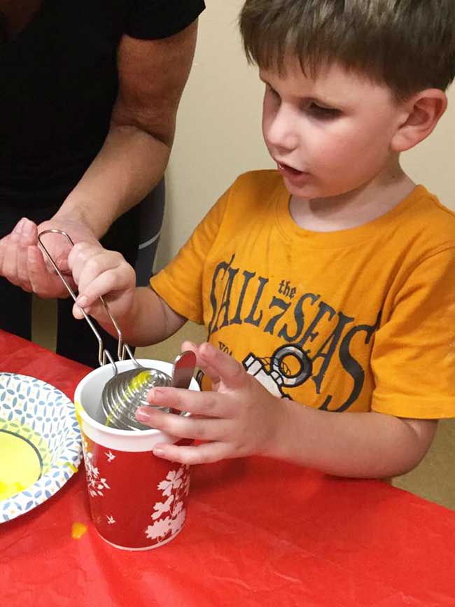 shows another BELL student separating egg white from egg yolk.