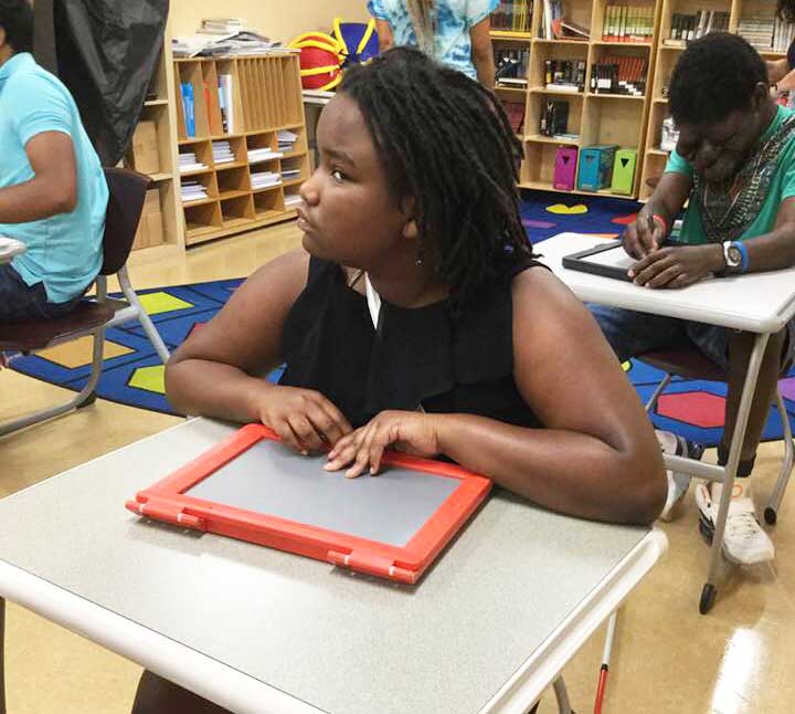 shows a girl examining what she has drawn on her Sketchpad.